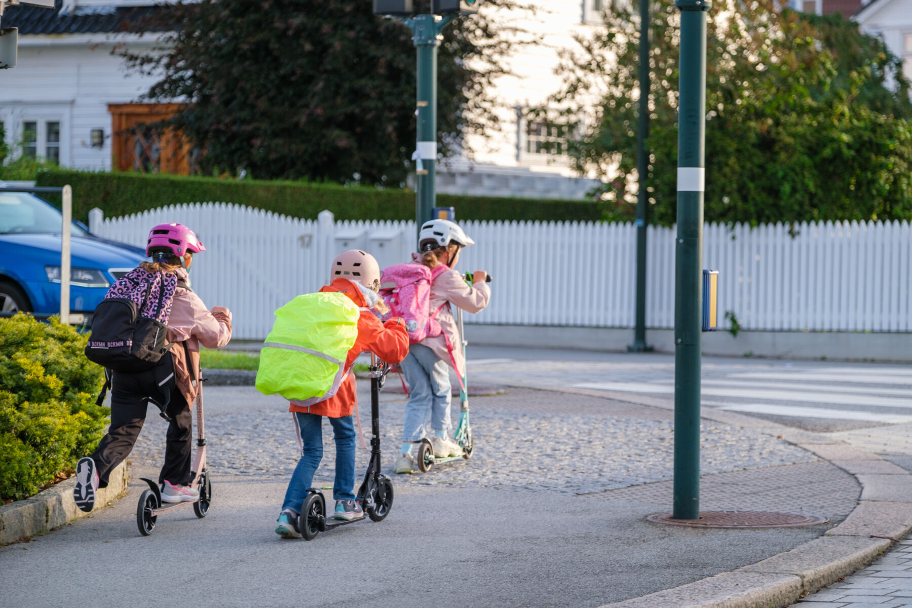 Barn på sparkesykkel som skal krysse en vei