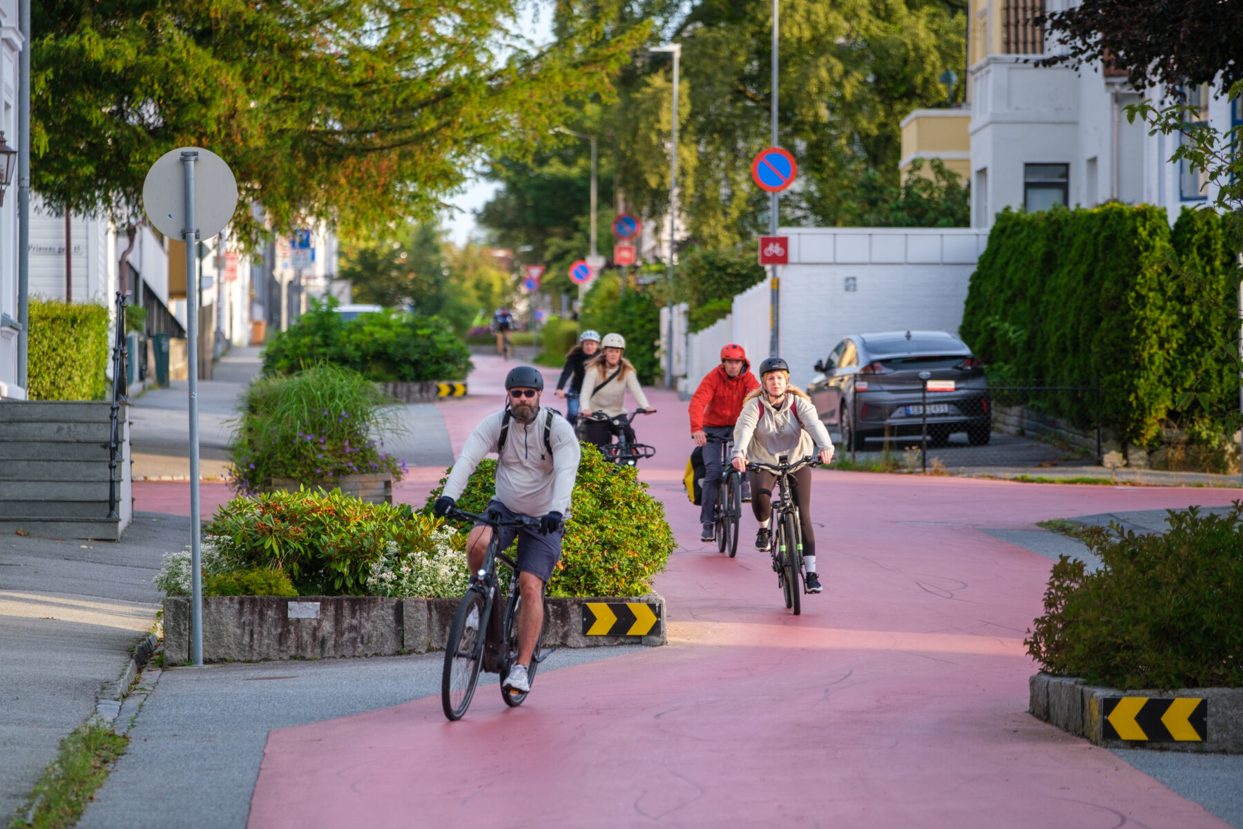Syklister på en stor og bred sykkelvei i et grønt landskap