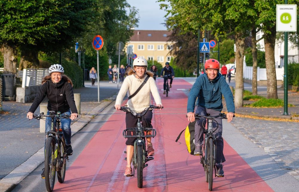 Tre glade syklister i Stavanger, med fint vær. De innbyr til hyggelig sykling.